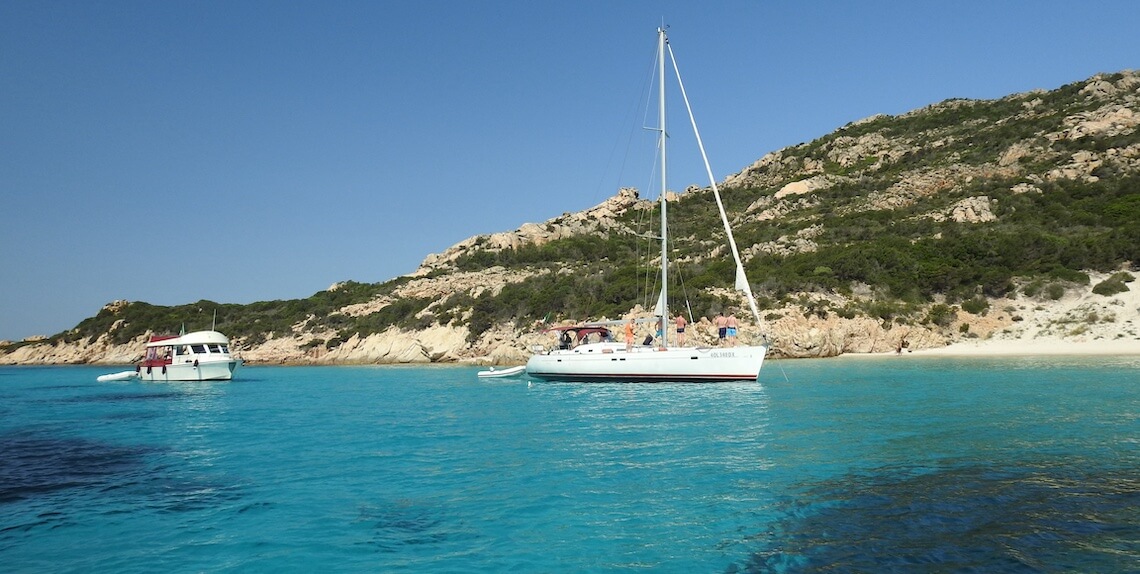 Met zeilboot liggen in baai op Sardinië